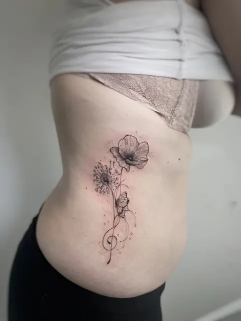 Tatuaggio: fiori e chiave di violino in fine line sul fianco, di Amanda - White Garden Tattoo, Roma Colli Aniene