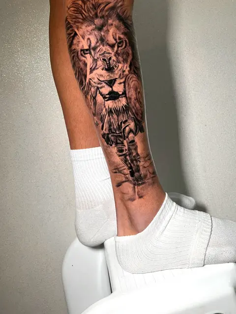 Tatuaggio: leone realistico in bianco e nero sulla gamba, di Francesco - White Garden Tattoo, Roma Colli Aniene