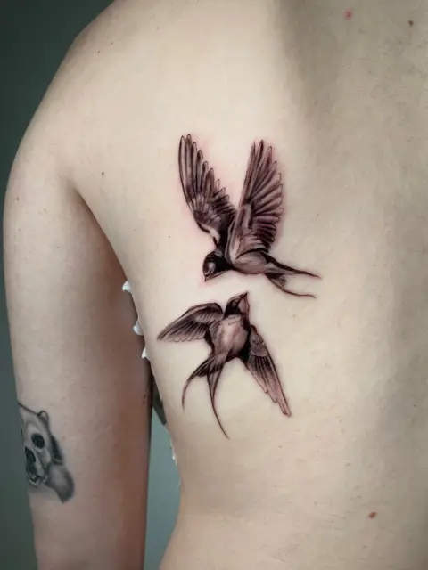 Tatuaggio: due rondini realistiche sulla schiena, di Francesco - White Garden Tattoo, Roma Colli Aniene