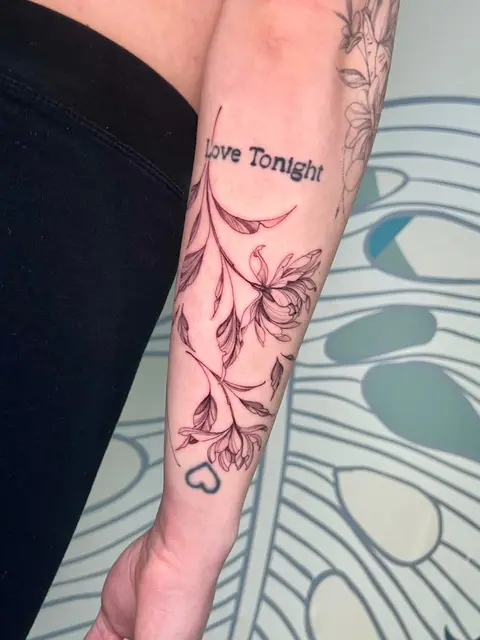 Tatuaggio: rami fioriti in fine line con la scritta Love Tonight sull'avambraccio, di Giada - White Garden Tattoo, Roma Colli Aniene