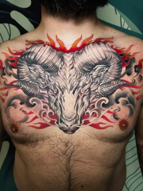 Tatuaggio: testa di ariete con fiamme a colori sul petto, di Irene - White Garden Tattoo, Roma Colli Aniene