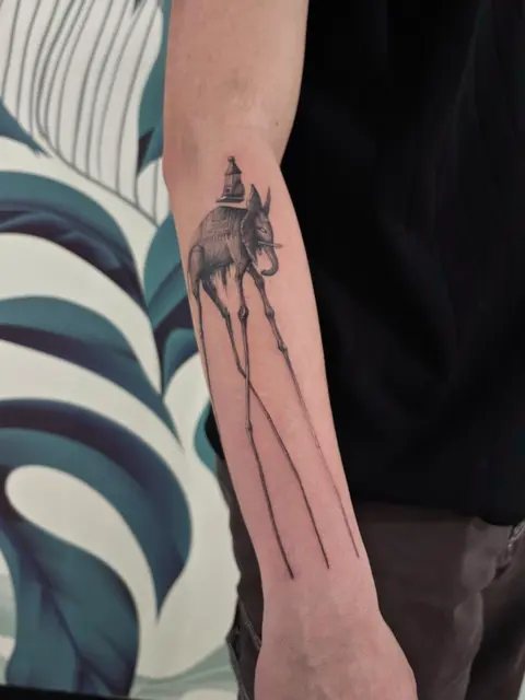 Tatuaggio: elefante ispirato a Dalí sull'avambraccio, di Massimiliano - White Garden Tattoo, Roma Colli Aniene