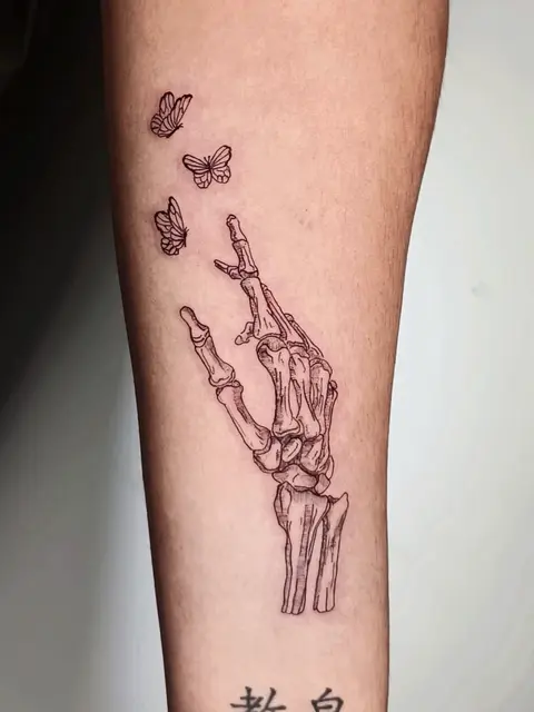 Tatuaggio: mano scheletrica con farfalle in linea, di Sara - White Garden Tattoo, Roma Colli Aniene